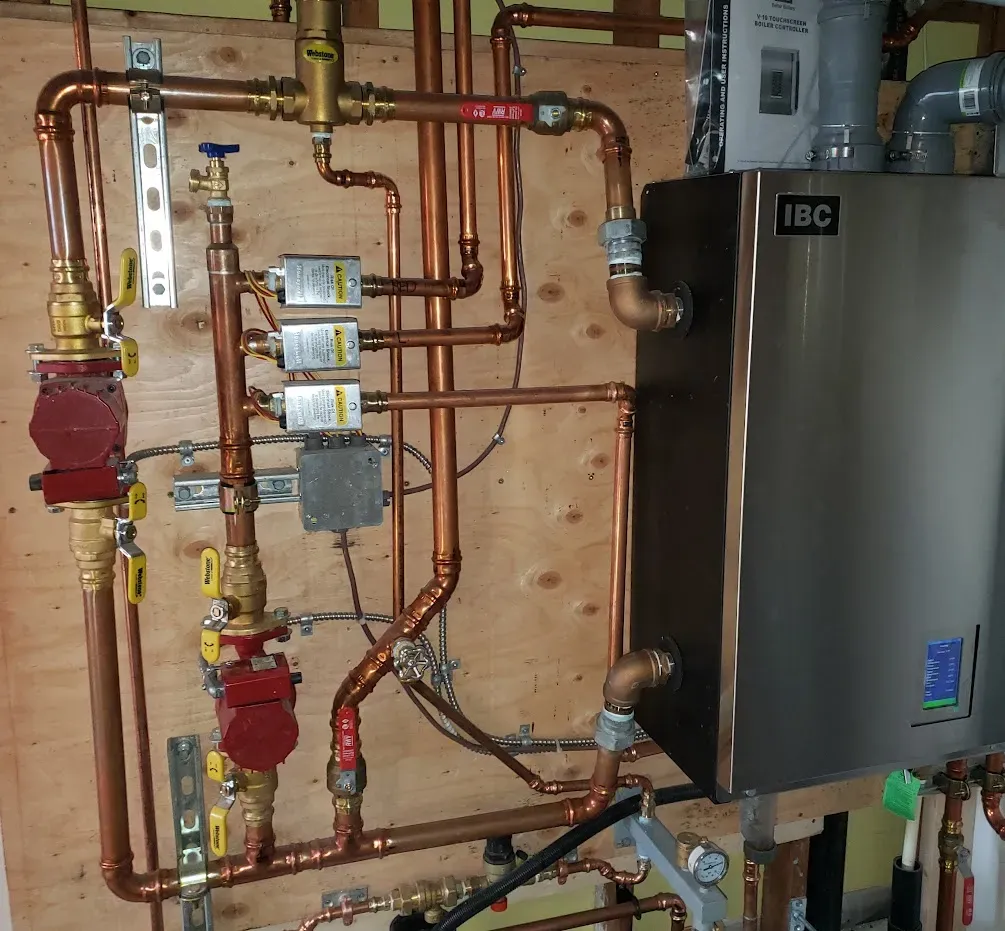 Red Seal technician reviewing a new boiler installation setup in a Surrey home